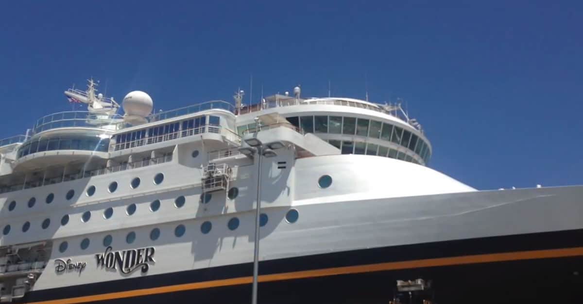 Disney Wonder cruise ship gleams docked beneath a bright sky—Disney magic ready to set sail for fans of unforgettable adventures.