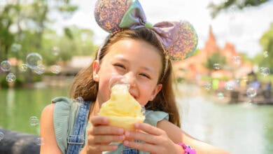 child wearing mickey ears and holding dole whip at disney world