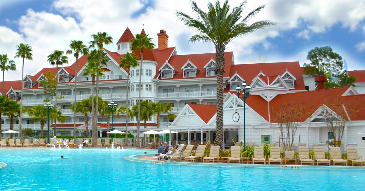 Disney Resort hotel with iconic red roofs, palm trees, and pool—ideal for fans to relax between park thrills and magical moments.