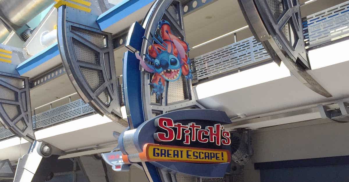 Stitch’s Great Escape! vibrant sign at Magic Kingdom, highlighting Stitch amid Tomorrowland theming; now an at-risk Disney attraction.