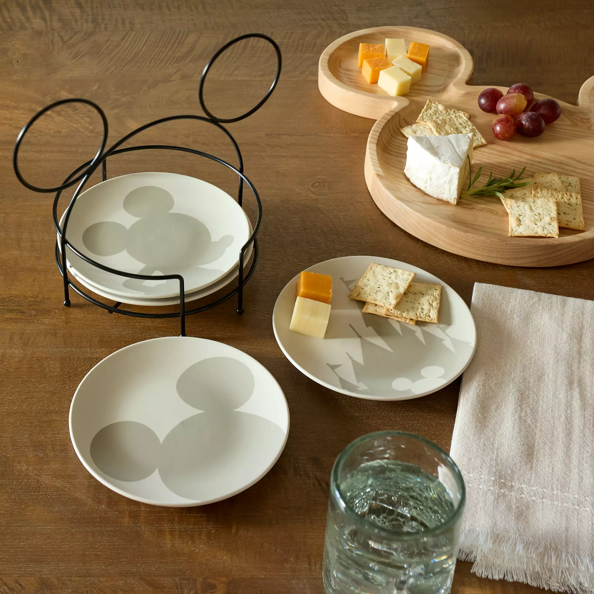 A wooden table set with Mickey Mouse-themed plates