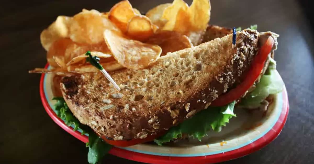 A Columbia Harbor House classic: multigrain sandwich with lettuce and tomato, plus potato chips—perfect fuel for park adventures.