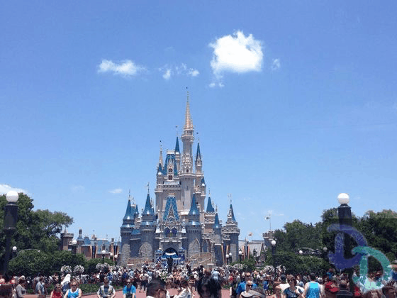 Excited guests gather before Cinderella Castle at Magic Kingdom, blue skies overhead as they prepare for a day of Disney magic.