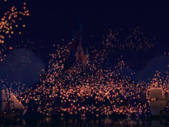Cinderella Castle illuminated at night, surrounded by floating lanterns in the sky and on water, like a Disney park spectacular.