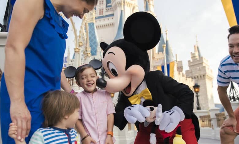 Mickey Mouse and kids standing in front of Cinderella's castle