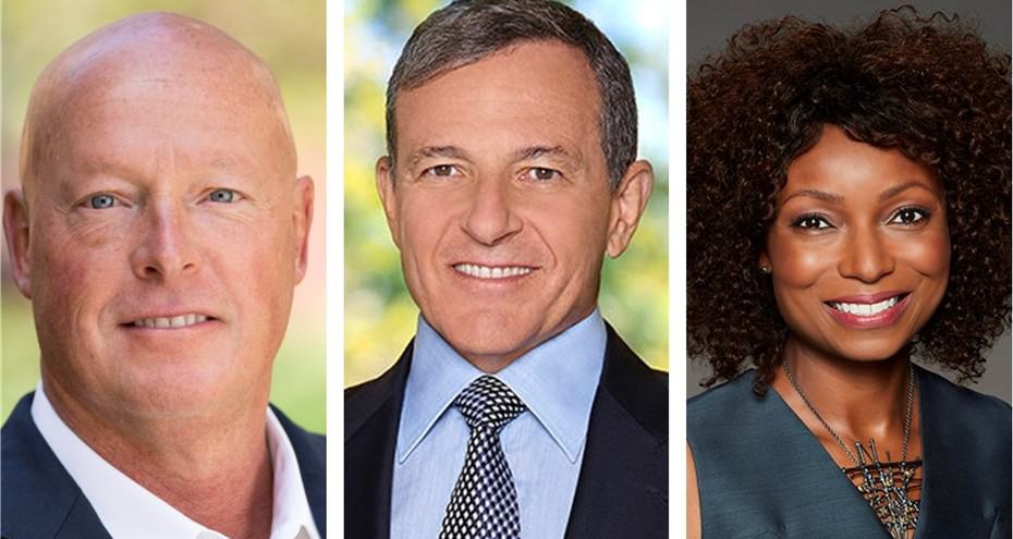 Three smiling Disney cast members—two men in suits and a woman in a dark top—pose portrait-style, radiating Disney magic.
