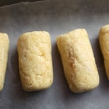 Four golden-brown rectangular cookies on parchment, a sweet treat inspired by your favorite Disney park Beaker Cake Pop Recipe.