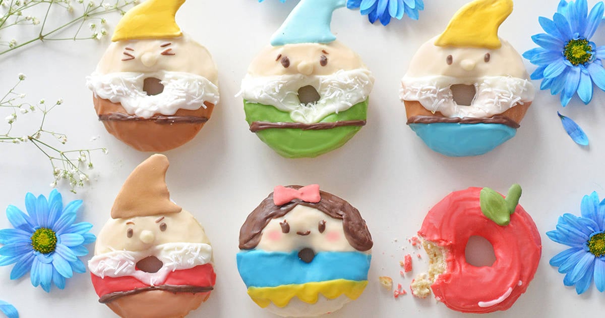 Six magical donuts inspired by Snow White and the Seven Dwarfs, featuring blue flowers and a signature bitten apple design.