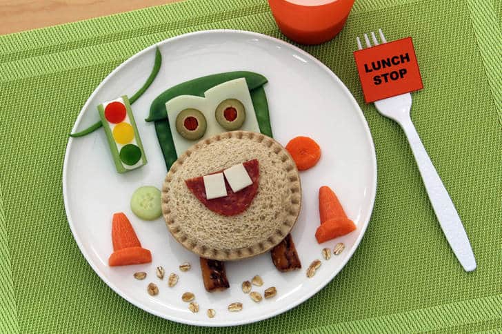 Tow Mater-themed lunch plate featuring a smiling car made of veggies and sandwich, with a “LUNCH STOP” fork—perfect for Pixar fans.
