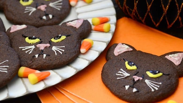 Binx the Cat-inspired chocolate cookies with icing and candy corn, served on orange napkins—perfect for a Disney Halloween party.
