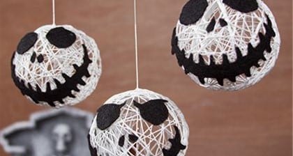 Jack Skellington string balls dangle as a whimsical garland, channeling Nightmare Before Christmas vibes for Halloween celebrations.