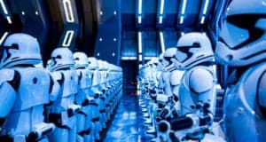 Rows of Stormtroopers in white armor stand in formation inside a futuristic, blue-lit spaceship corridor, reflecting the sci-fi aesthetic of the Star Wars universe.