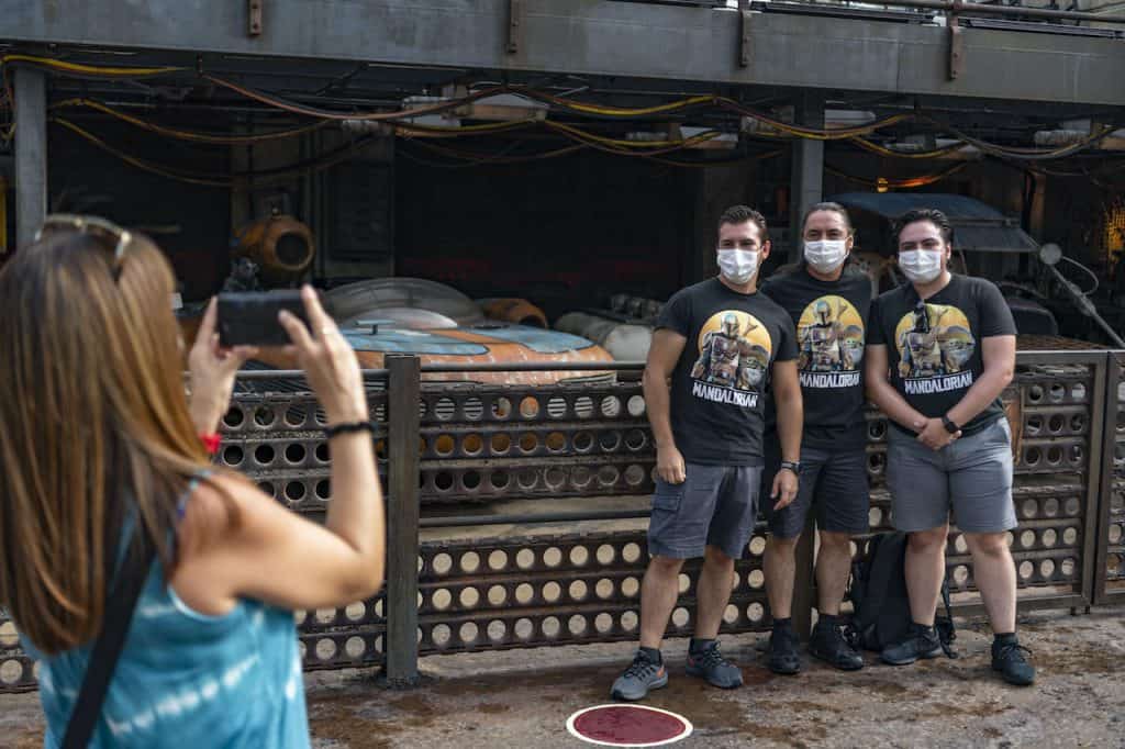Fans in matching shirts and masks celebrate an anniversary at Star Wars: Galaxy’s Edge, Disney’s Hollywood Studios.