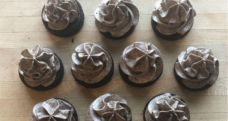 Disney Parks-inspired Grey Stuff cupcakes with cookies and cream frosting, styled for Disney fans, on a wooden table.