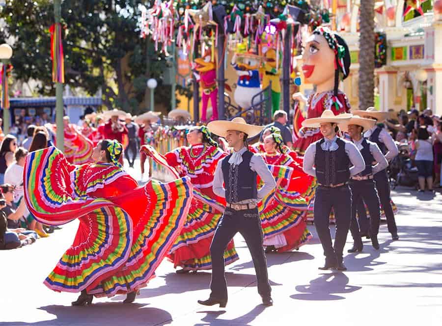 Folklorico dancers twirl in vibrant costumes and hats down Main Street, entertaining guests during the park’s Hispanic Heritage parade.
