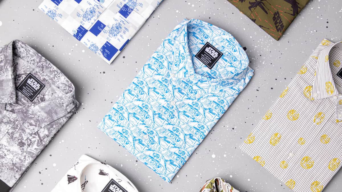 Star Wars-themed Original Stitch shirts with exclusive patterns, folded on a speckled gray surface, ready for fans.