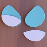 Ursula-inspired blue teardrop shapes with white accents on wood—ideal for fans creating Disney villain magic at home.