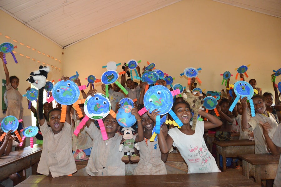 Kids in a Disney-sponsored classroom beaming with earth crafts, celebrating conservation magic and the Disney Conservation Fund.