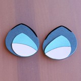 Spooky blue and white eye shapes on brown, resembling eerie theme park props for a haunted attraction or Halloween event.