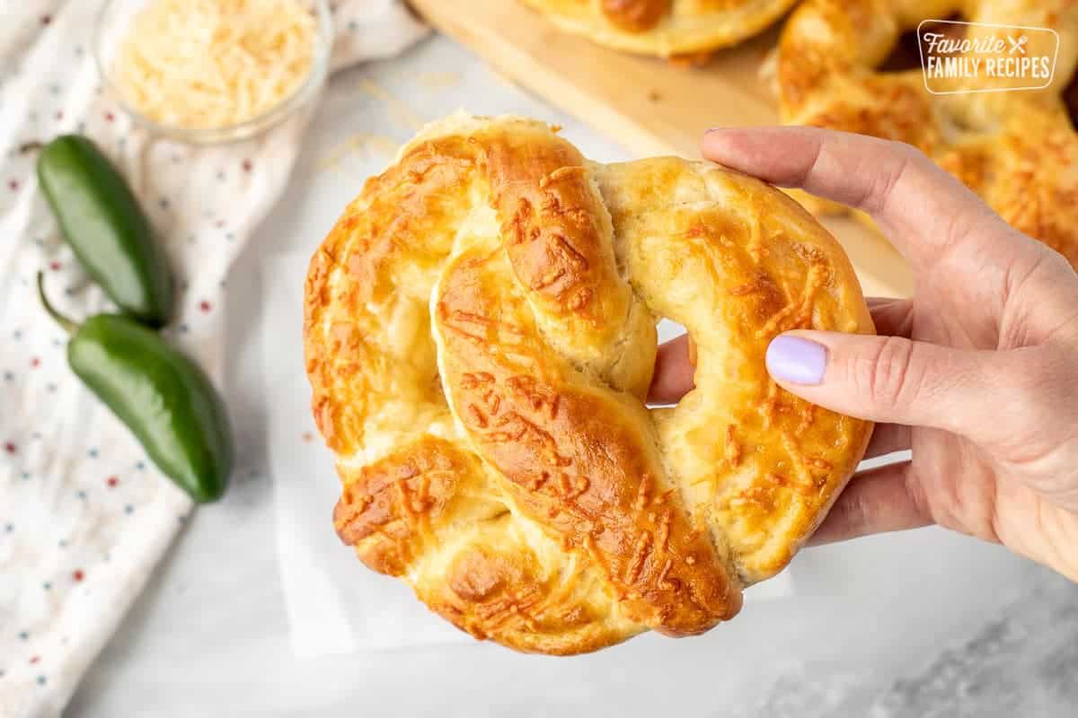 The Jalapeno Cheese Stuffed Pretzel is one of my very favorite treats at Disneyland. Now you can have this spicy, cheesy taste of Disney at home! Hand holding a Jalapeno Cheese Stuffed Pretzel.