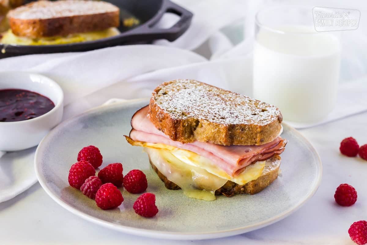 This Breakfast Monte Cristo Sandwich is a delicious twist on a classic! Sweet and savory meet together in this easy to make, decadent breakfast sandwich. Breakfast Monte Cristo Sandwich on a plate.