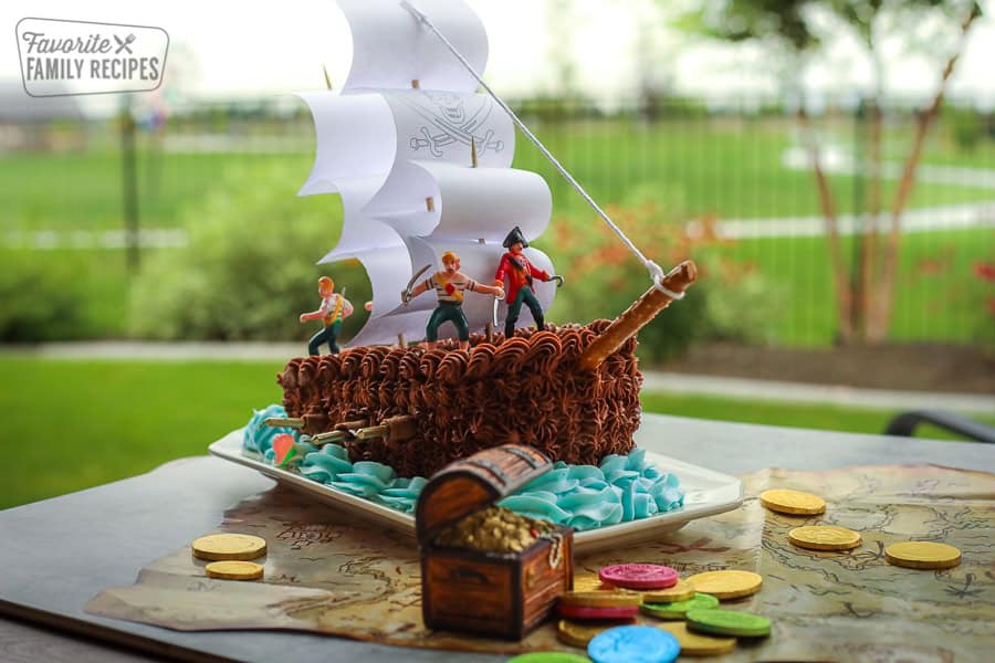 This Pirate ship birthday cake will be a HIT at your kid's next birthday party. Get all hands on deck and set your sails toward the kitchen! Pirate Ship Birthday cake on a pirate map surrounded by gold coins.