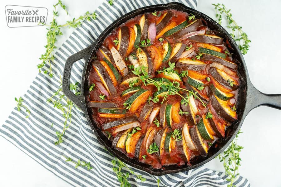 Ratatouille is the best way to enjoy fresh summer vegetables. This dish is delicious, healthy, and packed with flavor. Ratatouille in a cast iron pan with a black and white striped napkin.