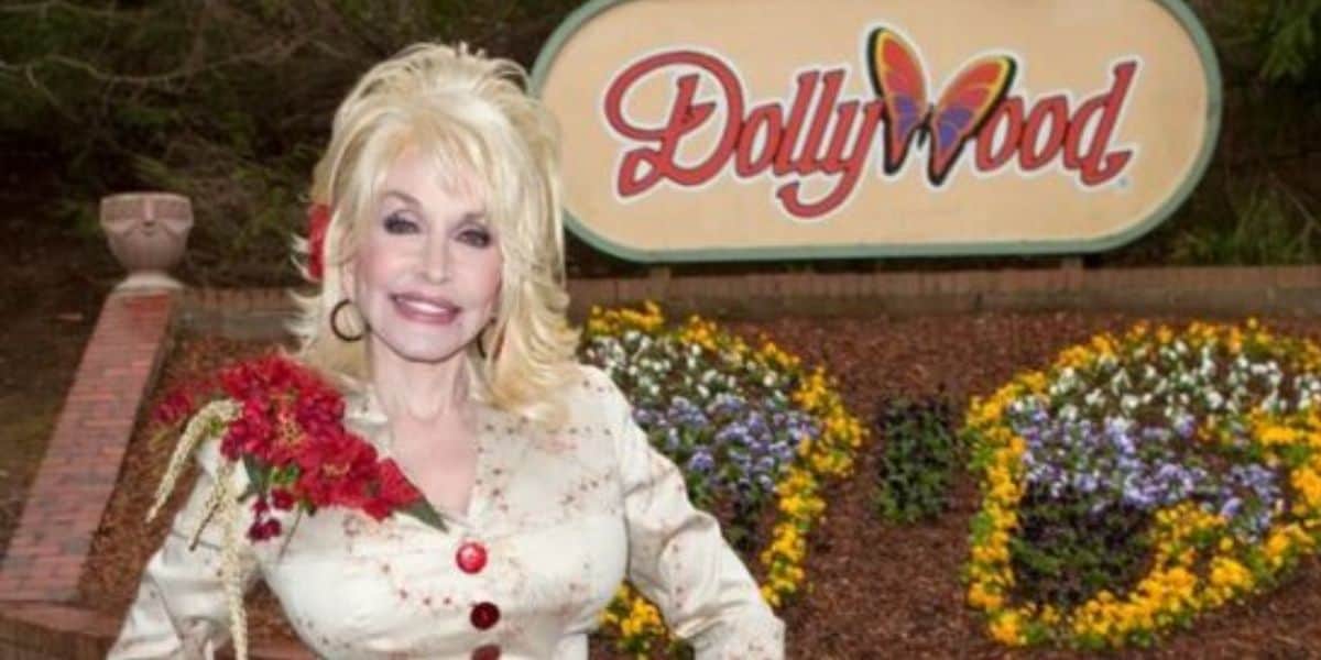 Dolly Parton in front of Dollywood sign