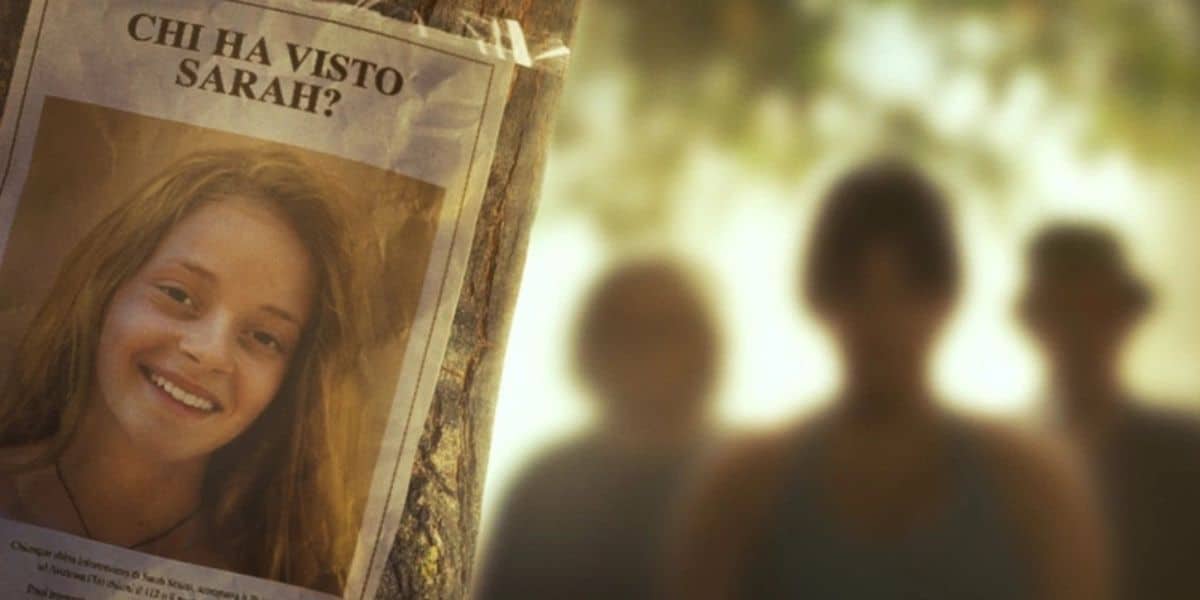 A missing person poster with the text "Chi ha visto Sarah?" is tacked to a tree, featuring a young woman smiling. In the blurred background, three people are standing slightly out of focus in Avetrana, echoing a scene more intense than any Disney Plus drama.