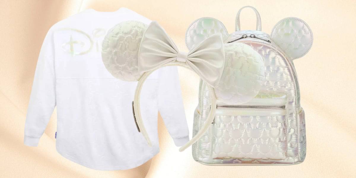 A white long-sleeve shirt with Disney written on the back, paired with a shiny, iridescent backpack featuring ear shapes on top. An ear headband with a white bow is also included. The background is a soft, peachy hue.