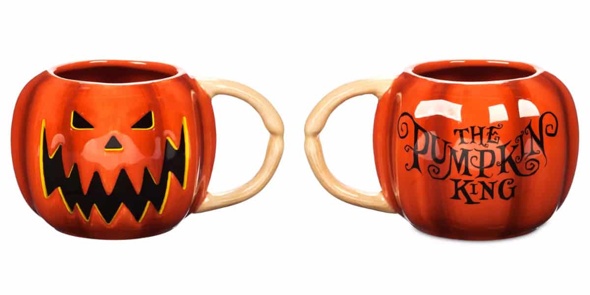 Two pumpkin-themed mugs. One has a carved jack-o'-lantern face, and the other reads "The Pumpkin King" in stylized text. Both mugs have beige handles resembling pumpkin stems.