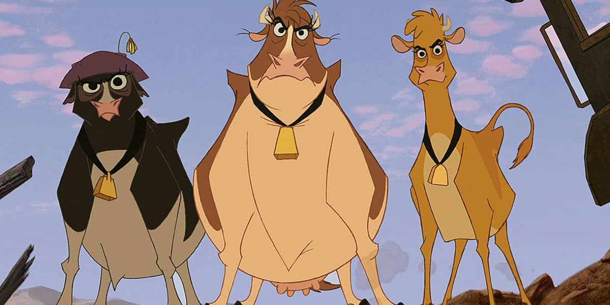 Three animated cows stand side by side, each wearing a bell around their necks. The background shows a clear blue sky. The cows have distinct expressions, and their colors are black and white, brown, and tan.