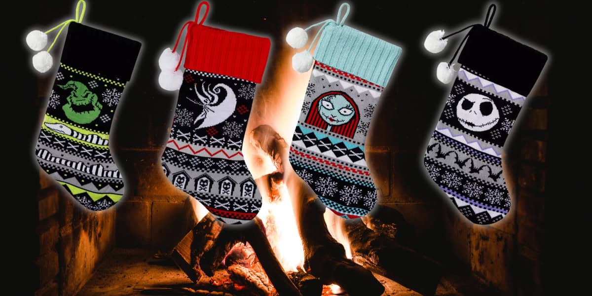 Four Christmas stockings with themed designs hang in front of a lit fireplace. Each stocking features different characters and patterns in black, white, red, green, and turquoise colors, adding a festive touch.