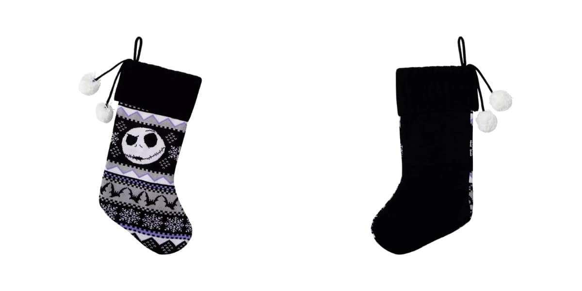 Two Christmas stockings are displayed. The left stocking is black and white with a skull pattern, snowflakes, and zigzag designs. The right stocking is plain black. Both have fluffy white pom-poms attached at the top.