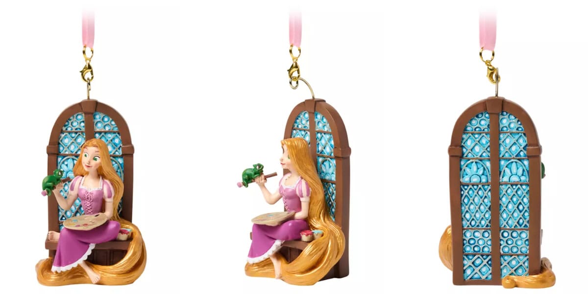 A decorative ornament of a princess with long, golden hair, wearing a purple dress, holding a palette, and seated by a window. The ornament is shown from three angles: front, side, and back. A green chameleon sits on her shoulder.
