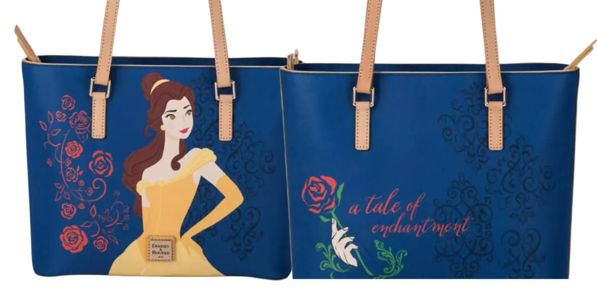 Two blue handbags featuring a princess in a yellow dress on one side and floral designs with the text "a tale of enchantment" on the other. The bags have tan handles and decorative patterns.