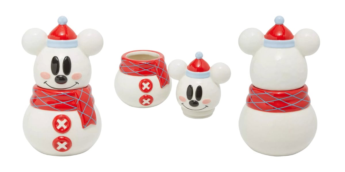 Ceramic snowman-shaped cookie jar and mug set with a cartoon face and red and blue hats and scarves. The jar has removable head and body sections with red buttons, and the mug has a face and hat design.