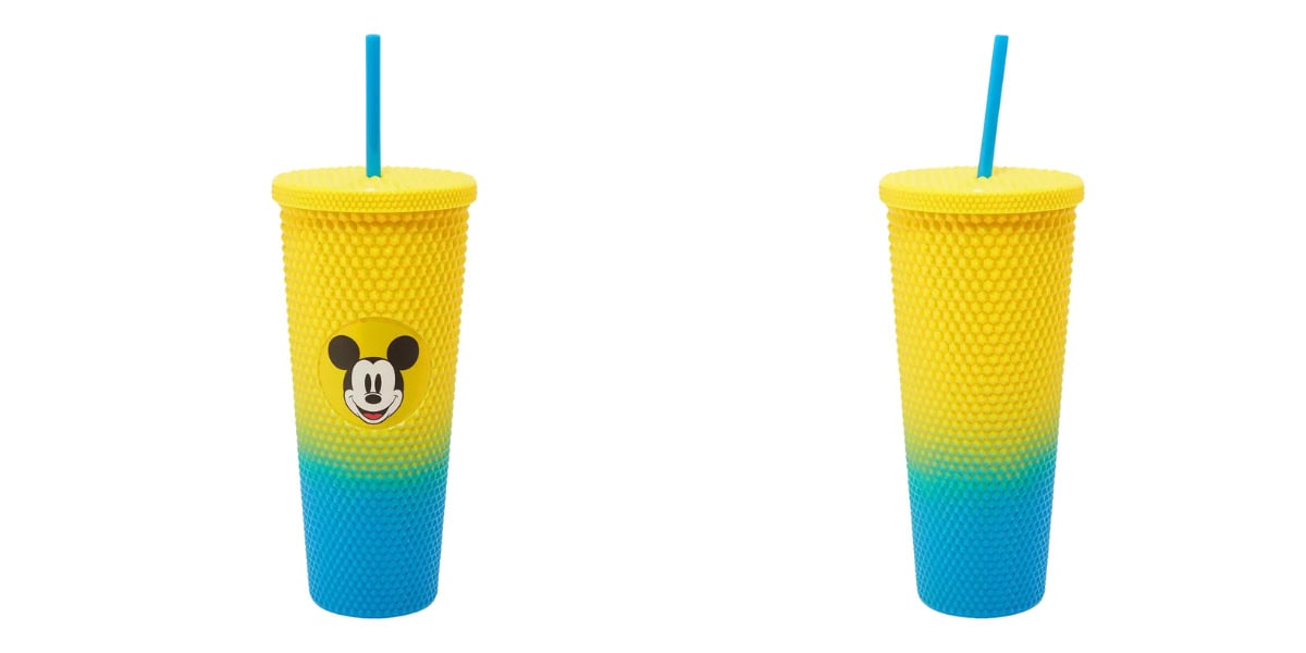 A textured tumbler with a straw, featuring a yellow top and bottom gradient to blue. The tumbler has a Mickey Mouse face logo on it.