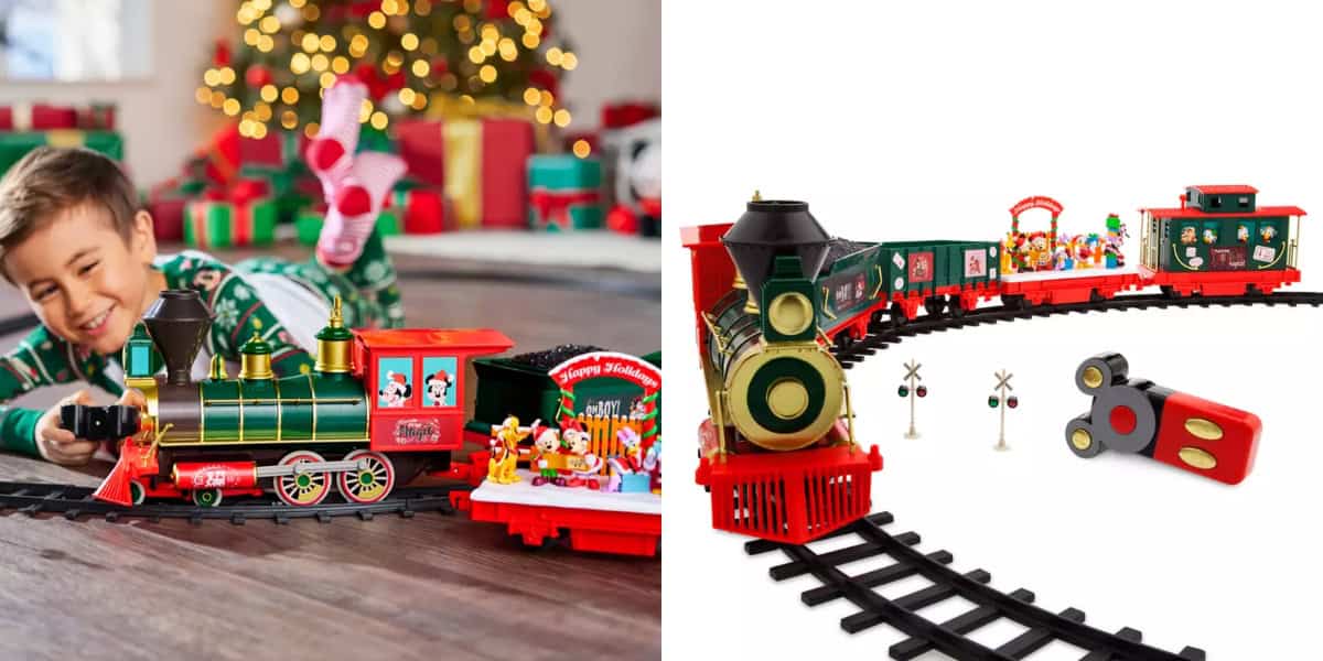 A child in pajamas excitedly plays with a colorful toy train set on the floor by a Christmas tree with presents. The train set features a festive locomotive and wagons on a circular track, complete with mini figurines and accessories.