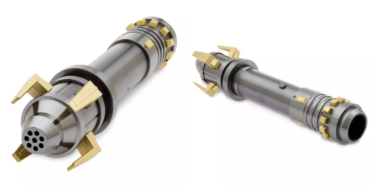 A metallic cylindrical object with gold accents, resembling a sci-fi weapon or tool, is displayed in two angles. The object features multiple grooves, protruding golden fins, and a vented tip on one end. The background is plain white.