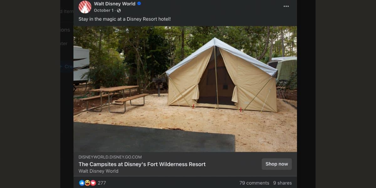 A large, tan tent sits on a sandy campsite surrounded by trees. Nearby, a picnic table and campfire ring are visible. The setting is peaceful and inviting, part of Disney's Fort Wilderness Resort.