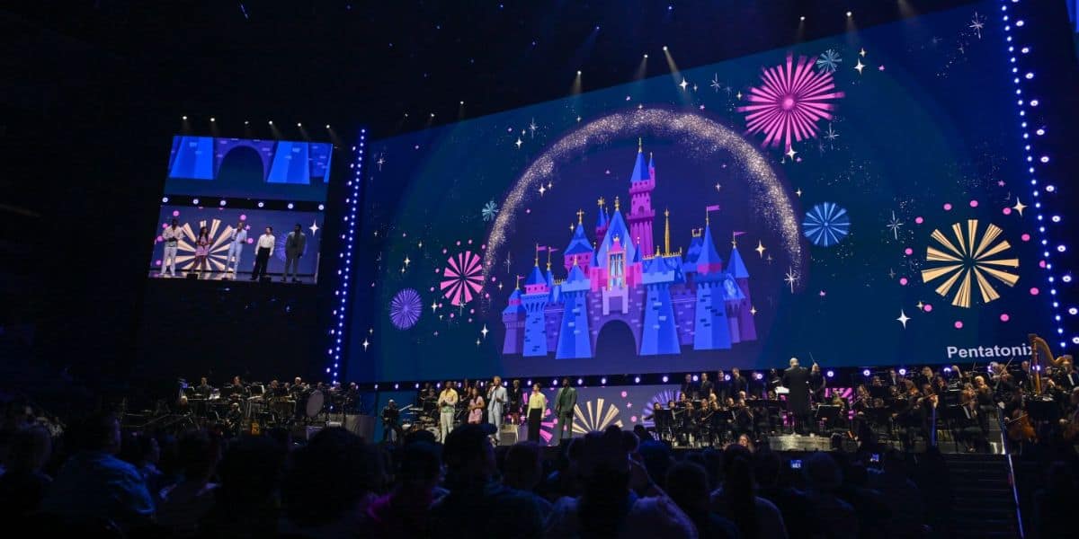 People are gathered in an auditorium for D23
