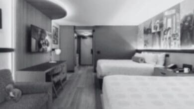 A black and white photo of a double bed hotel room at Disneyland Resort's Pixar Place Hotel.
