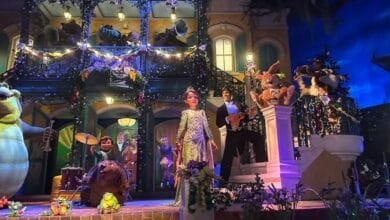 A vibrant stage with animatronic animals and human figures dressed in elegant attire.