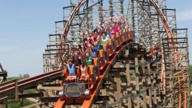 A group of people ride a wooden roller coaster at Six Flags Great America, a Six Flags theme park.