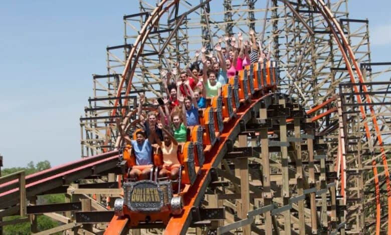 A group of people ride a wooden roller coaster at Six Flags Great America, a Six Flags theme park.