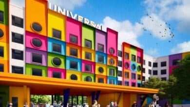 A colorful hotel with a bold, modern design featuring square and circular windows, bright panels in orange, green, yellow, and pink, with “UNIVERSAL” on the roof, and people gathered outside in Texas.