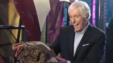 Dick Van Dyke smiles as he looks at the carpet bag from Mary Poppins