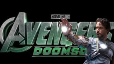 A man wearing a glowing mechanical arm stands in front of a stylized "Avengers: Doomsday" movie logo, holding up his hand with light shining from his palm.
