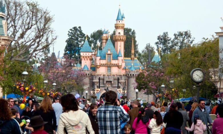 Crowds on Main Street, USA, at Disneyland Park, in front of Sleeping Beauty Castle. Disney bus service.